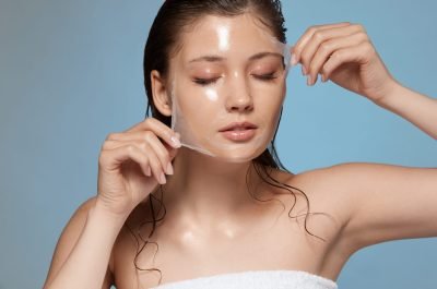 pretty female taking off purifying mask with her eyes closed, girl with wet hair removing moisturizer, fresh and clean skin