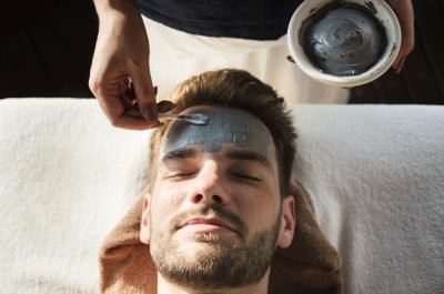 Man getting a mud mask at a spa